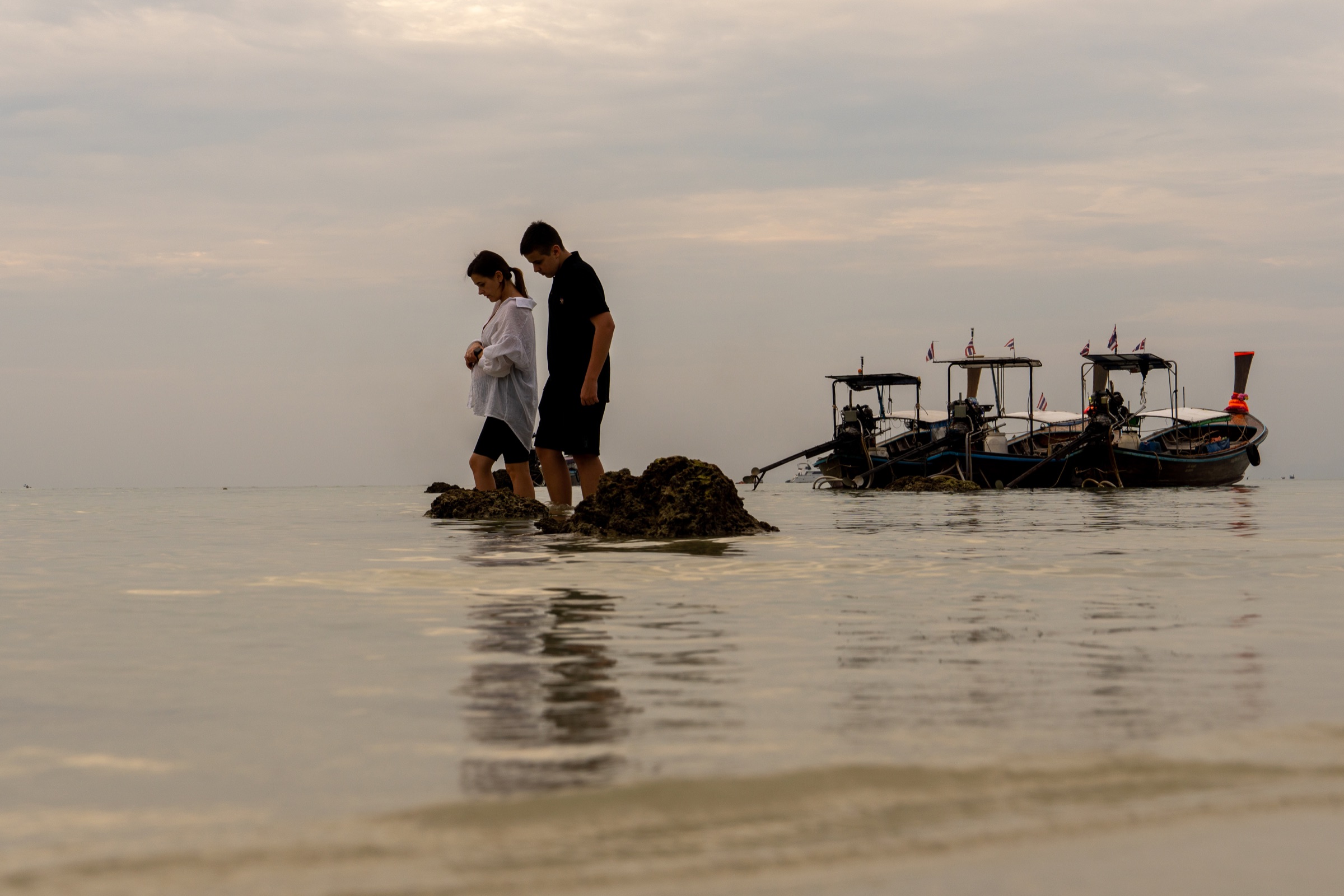 Dois turistas atravessando a área descoberta pela maré em Koh Phi Phi